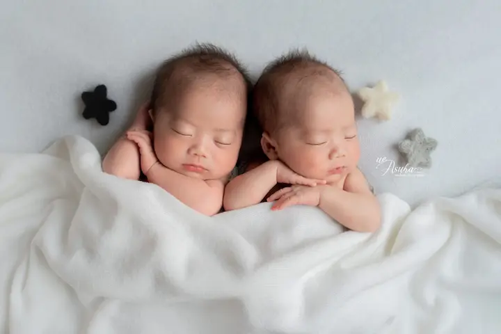 ニューボーンフォト_星のデコレーションの下で眠る双子の新生児