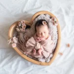 ニューボンフォト_お花に囲まれたハートボウルの中でピンクのおくるみに包まれた赤ちゃん01