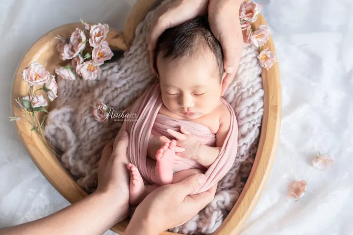 ニューボンフォト_お花に囲まれたハートボウルの中でピンクのおくるみに包まれた赤ちゃん03
