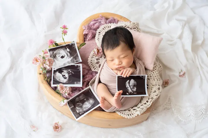 ニューボーンフォト_エコー写真と一緒にバスケットに入った新生児