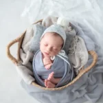 ニューボーンフォト_グレーの布に包まれたバスケットの中の新生児