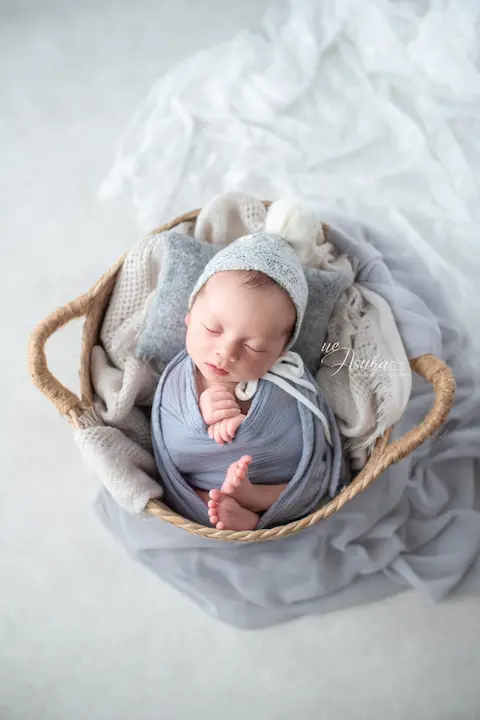 ニューボーンフォト_グレーの布に包まれたバスケットの中の新生児
