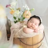 ニューボンフォト_生花を添えた木製バケツで眠る新生児