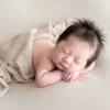 ニューボーンフォト_ベージュの布にくるまれて眠る赤ちゃん1