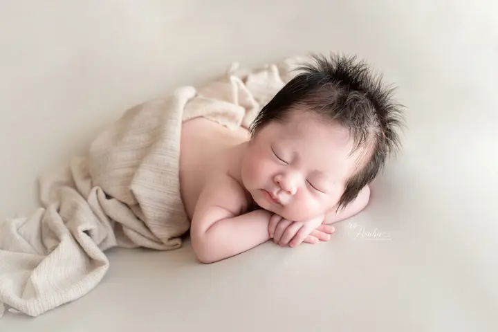 ニューボーンフォト_ベージュの布にくるまれて眠る赤ちゃん1