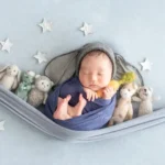 ニューボンフォト_ぬいぐるみと星モチーフハンモックに包まれる新生児