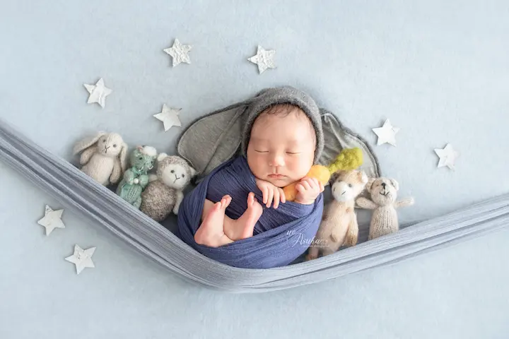 ニューボンフォト_ぬいぐるみと星モチーフハンモックに包まれる新生児