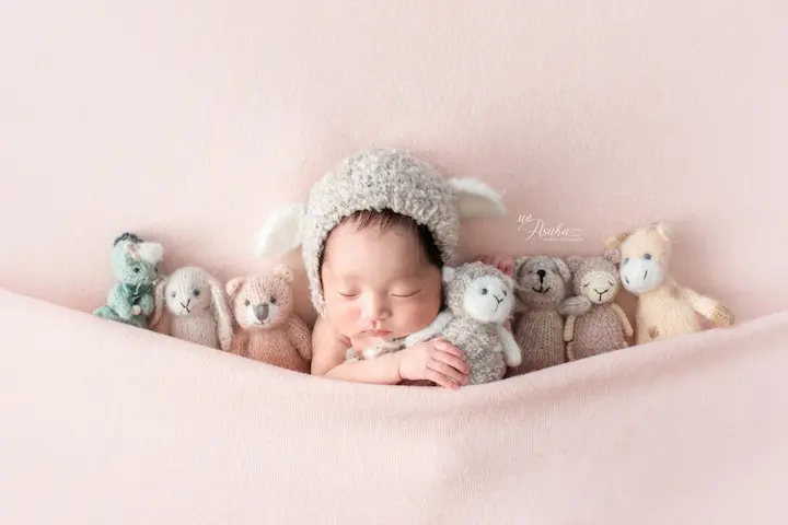 ニューボーンフォト_ふわふわ帽子をかぶった赤ちゃんとぬいぐるみの友だち