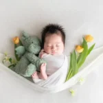 ウサギとチューリップとともに眠る新生児