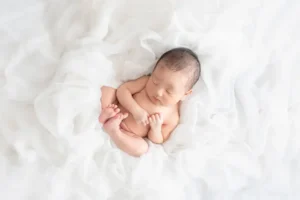 河内長野のニューボーンフォト白い布に包まれる男の子